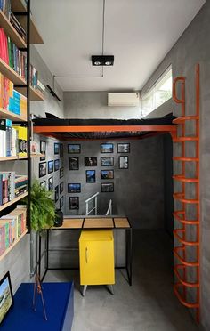 a man sitting on top of a bunk bed next to a desk and bookshelf