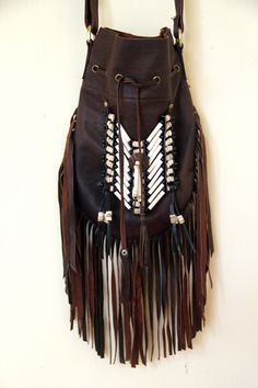 Medium fringed leather bag, antique brown color, boho style Handcrafted bone bead and natural coconut bead embellishment choker attached as decoration Fully lined inside with one pocket. The adjustable leather shoulder strap fits either across the body or slung over your shoulder. Material: leather, cow bones,coconut bead, turquoise crystal bead 8.2 in wide, 11.4 in long. total long include feather fringes 18.9 in aprox 21 cm wide,29 cm long. total long include leather fringes 48 cm aprox Best f Vintage Leather Bags With Fringe, Bohemian Leather Hobo Bag With Tassels, Bohemian Brown Shoulder Bag, Brown Shoulder Bag For Festival, Brown Fringe Hobo Shoulder Bag, Brown Leather Shoulder Bag For Festivals, Bohemian Brown Hobo Bag, Bohemian Leather Bag With Tassels, Festival Brown Fringe Hobo Bag