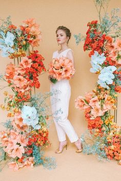 a woman standing in front of an arrangement of flowers