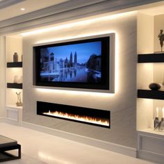 a living room with a large flat screen tv mounted on the wall next to a fire place