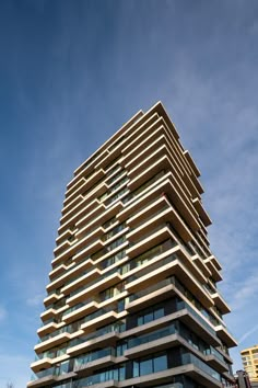 a very tall building with lots of windows on it's side in front of a blue sky