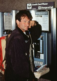 a man standing in front of a phone booth