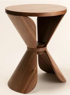 a wooden table with an unusual design on the top and bottom, sitting in front of a white background