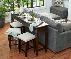 a living room filled with furniture and a table topped with plates of food on top of it