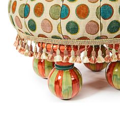 an ottoman covered in multicolored circles and tassels