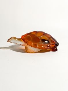 a glass turtle sitting on top of a white surface