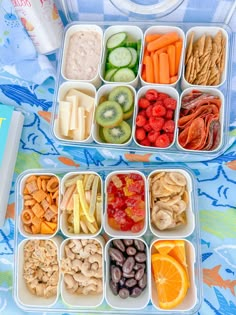 two plastic containers filled with food on top of a blue and white table cloth next to an open book