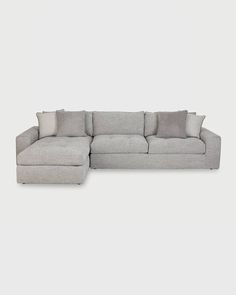 a large sectional couch with pillows on the top and bottom part, in front of a white background