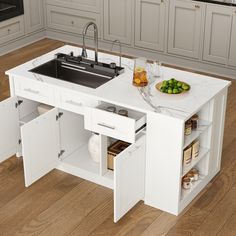 a white kitchen island with sink and open cupboards next to it on hardwood flooring