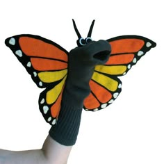 a hand holding a stuffed butterfly in the air