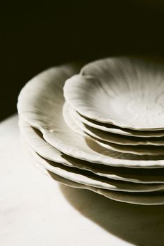 a stack of white plates sitting on top of a table