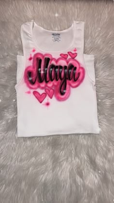 Designs by Galveston Airbrush! ♡ Feel free to contact me with any questions or custom orders. ✧ Our Designs on these cute White beater Tank tops are handmade with the artists' skilled Hands and that makes each item unique ✧ Each design includes up to TWO names or words with up to THREE specified COLORS. SIZES: Available for ADULTS and YOUTH DESIGN PLACEMENT: All designs are airbrushed on the FRONT of our White Beater Tank top unless specified otherwise. International orders may have an additiona Cute Cotton Racerback Tank Top, Customizable Trendy Pink Tops, Customized Casual Cotton Tops, White Sleeveless Top With Custom Print, Customizable Sleeveless Tops, Wife Beater Tank, Airbrush Clothes, Airbrushed Tanks, Airbrush Shirts