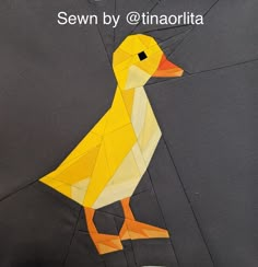 a yellow duck sitting on top of a piece of fabric