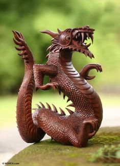 a statue of a dragon sitting on top of a rock