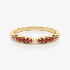 a yellow gold band with red stones on the sides and an arrow design in the middle