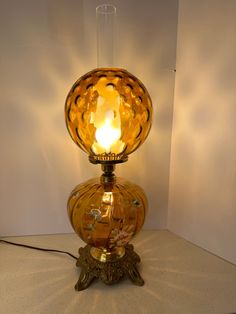 a glass table lamp with a light on it