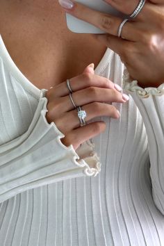 a woman with two rings on her finger holding a cell phone in her right hand