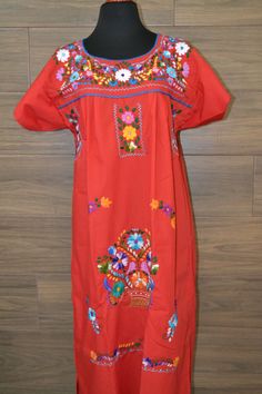 "This lovely red was handmade in Mexico. The beautiful colorful flowers were embroidered by hand, so each one is unique. You will love wearing this comfortable cotton dress with short sleeves. It is perfect for a hot summer day. This dress comes just above or below the knee, depending on how tall you are. It has a square neckline and cute little puffy sleeves. The measurements on this dress are 21\" wide x 44\" long. It has a 9\" opening for the neck and 10\" sleeve openings. Size Large About Ou Red Bohemian Embroidered Dress With Intricate Embroidery, Red Bohemian Embroidered Dress With Floral Details, Red Bohemian Dress With Floral Embroidery, Red Folk Embroidered Dress With Floral Design, Red Folk Style Dress With Floral Embroidery, Red Folk Style Dress With Intricate Embroidery, Red Folk Style Dress With Embroidered Hem, Folk Style Red Dress With Embroidered Hem, Spring Bohemian Dress With Traditional Patterns