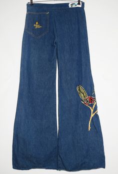 "Vintage Antonio Guiseppe embroidered denim jeans with snap button, zip fly and butterflies embroidery from the 70's, made in USA - Size tag: Please always check measurements before buying. Size tag is faded, On the top fits like Women's M/L but the jeans are very long, so please check measurements. - Measurements (laying flat): Waist: 16\" Outleg: 46\" Inleg: 35.5\" Thigh: 11.5\" Rise: 10.5\" Leg opening: 13.5\" -Wear: /Please see images for details/ Good vintage condition. Fabric pulls/bubbles throughout, please zoom in the pictures. - Fabric: Cotton *All of our items are preloved pieces so some signs of natural wear and age are to be expected. Please look through the photos carefully to check if the condition is to your satisfaction.  *All efforts are made to show any defects however sm Wide Leg Denim Flare Jeans With Floral Embroidery, Embroidered Wide Leg Denim Flare Jeans, Embroidered Wide Leg Medium Wash Jeans, Embroidered Wide Leg Flare Jeans In Denim Blue, Embroidered Denim Blue Cotton Flare Jeans, Retro Embroidered Bottoms For Spring, Vintage Pants With Floral Embroidery For Spring, Embroidered Denim Flare Jeans For Fall, Fall Embroidered Denim Flare Jeans