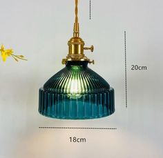 a blue glass pendant light hanging from a gold colored ceiling fixture with measurements for the length