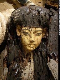 an ancient statue is made out of wood and has been carved into the shape of a woman's head