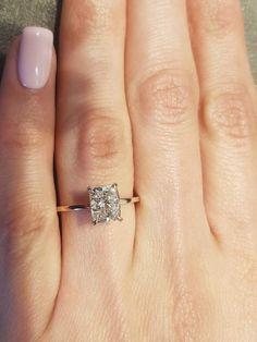 a woman's hand with a ring on it and a diamond in the middle