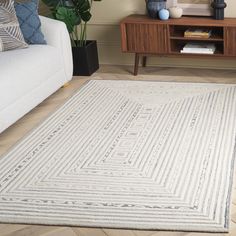 a living room with a white couch and rug