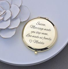 a compact mirror sitting on top of a plate next to a flower