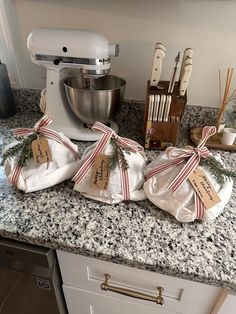 three bags tied with twine are sitting on the kitchen counter next to an electric mixer