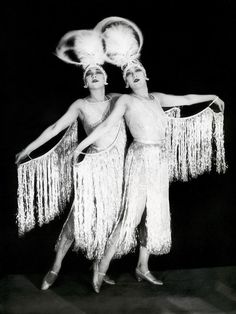 two women in white dresses with fringes on their heads and one has a quote about how fun is that?