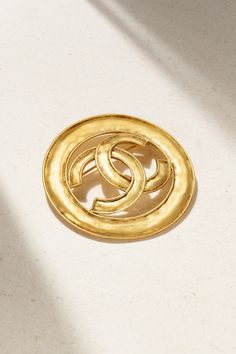 With over 40 years' experience in the vintage jewelry industry, Susan Caplan has a keen eye for sourcing and authenticating exquisite finds that you'll treasure for a lifetime. Marked and dated circa '94, this Chanel brooch is made from hammered gold-plated metal and detailed with the iconic 'CC' medallion. Pin yours to the lapel of your favorite blazer.  This Chanel item has been authenticated by Susan Caplan. Susan Caplan is not affiliated or endorsed by Chanel. Timeless Formal Jewelry With Gold-tone Logo Plaque, Luxury Round Brooches For Collectors, Luxury Round Collectible Brooches, Silver Jewelry With Gold-tone Logo Plaque As Gift, Classic Round Jewelry Brooch, Classic Brooch For Anniversary, Designer Formal Brooch Jewelry, Luxury Round Brooches For Formal Occasion, Luxury Gold-tone Brooch Jewelry