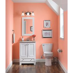 a bathroom painted in peach and white with wood flooring on the wooden floors is shown