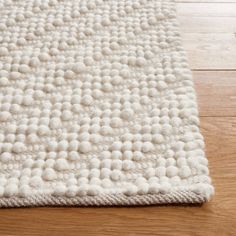 a white rug on top of a wooden floor with an area rug in the middle