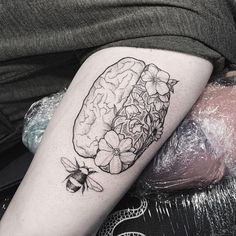 a black and white photo of a person's leg with flowers on it