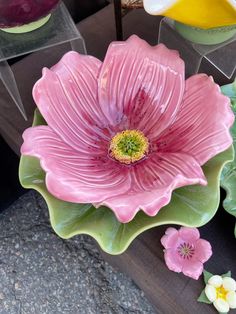 some pink flowers and green leaves on a table