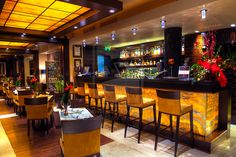 a restaurant with yellow chairs and bar stools