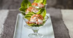 shrimp and lettuce are served in small glass dishes