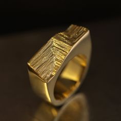 The Xyz Signature ring draws inspiration from modern architecture's Cartesian geometry and mineral structures. To balance against the minimalist solid, Agata hand-carved an intersting pattern on its front that imitates growing crystals forming parallel stritations on the surface. This intricate mineral pattern contrasts beautifully with high-polished surfaces of the ring. Made in 18k gold, this heavyweight ring stands out with its modernist and dynamic aesthetics. Despite its blocky and slightly Growing Crystals, Signature Ring, Signature Rings, Ring Stand, The Palm, Modern Aesthetics, The Minimalist, Bosnia And Herzegovina, Modern Architecture