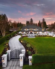 an aerial view of a home with driveway and gate leading to the front yard at dusk