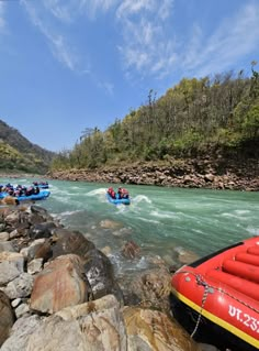 people are rafting down the river on rocks