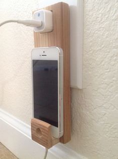 an iphone is plugged into a charger attached to a wall mounted charging station