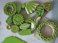 some green and white items sitting on top of a table next to paintbrushes