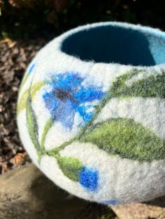 a blue flower vase sitting on top of a rock