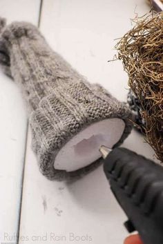 a pair of scissors is used to cut the ends of a knitted mitt