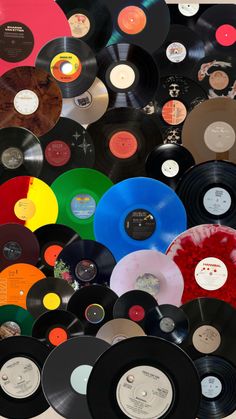 many different colored records are stacked on top of each other in the same pattern and size