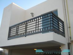 a white building with a black balcony and balconies