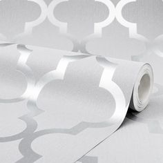 a white and silver wallpaper with circles on it's side, next to a roll of tape