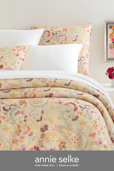 an image of a bed with white linens and flowers on the comforter cover