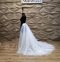 a white wedding dress on display in front of a wall with a sign that says viz dress