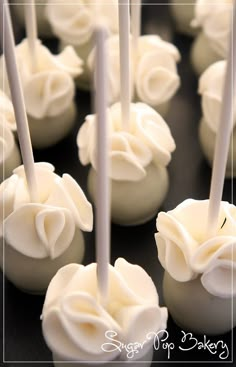 there are many white cake pops with icing on them